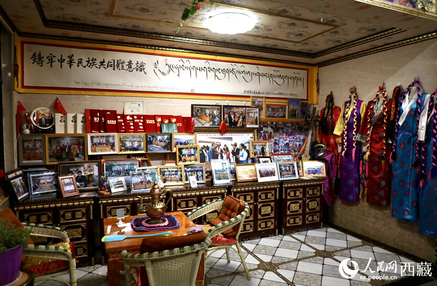 米瑪央吉家庭旅館一角，這里擺放著她們和游客的合影，以及近些年她們家所獲得的獎狀。人民網(wǎng)記者 次仁羅布攝