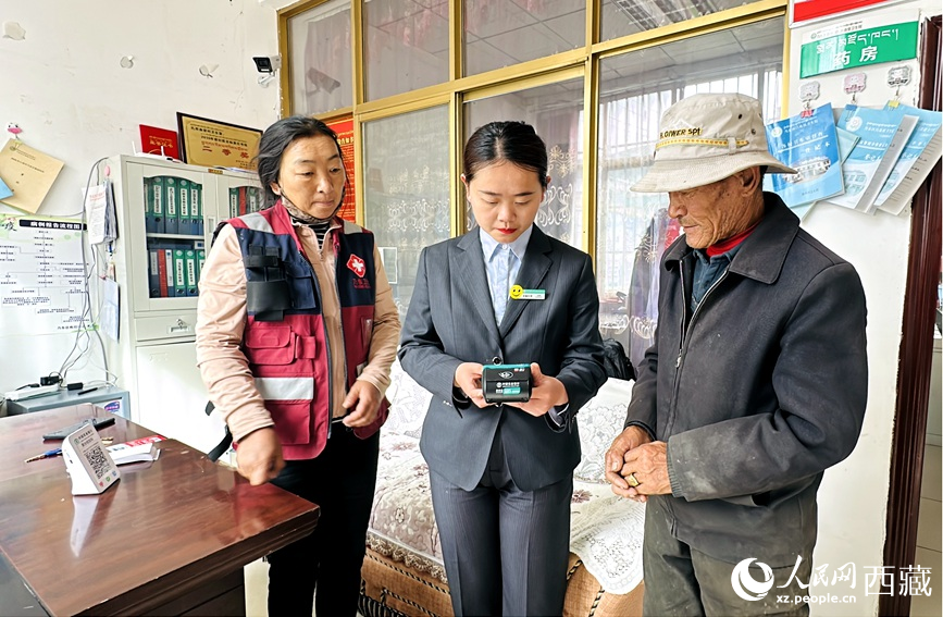 農(nóng)行乃東支行客服經(jīng)理伍思琪（右二）在為群眾提供金融服務(wù)。人民網(wǎng)記者 次仁羅布攝