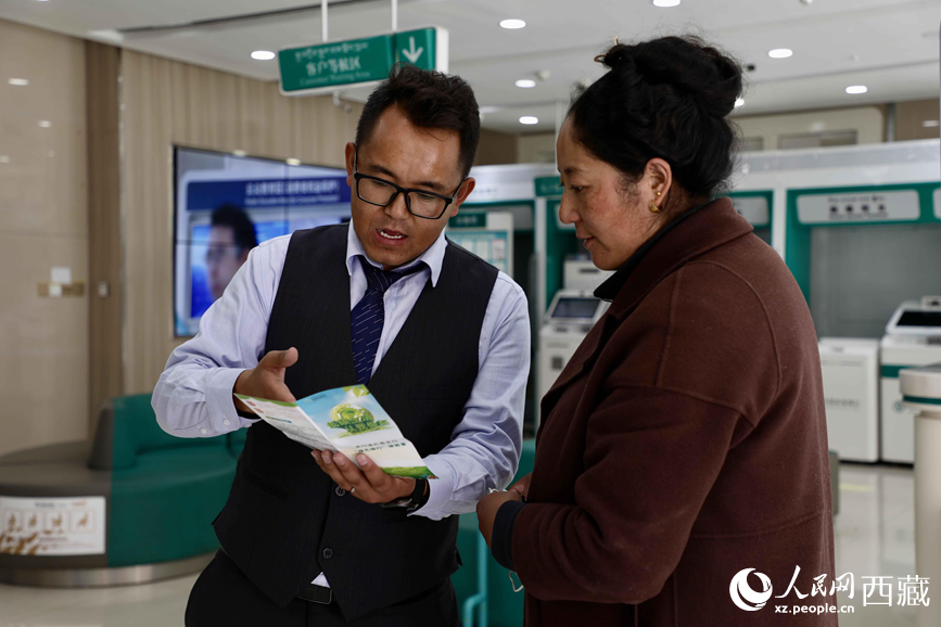 農(nóng)行洛扎縣支行工作人員在向辦事群眾講解“個人碳賬戶”。 人民網(wǎng)記者 次仁羅布攝