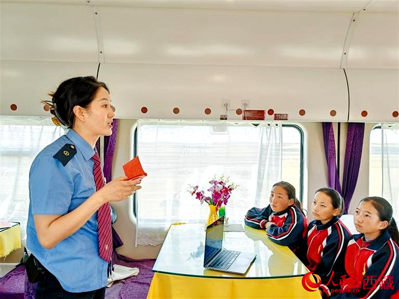 四朗卓嘎（左）為孩子們講述青藏鐵路建設(shè)的故事。人民日報(bào)記者 徐馭堯攝