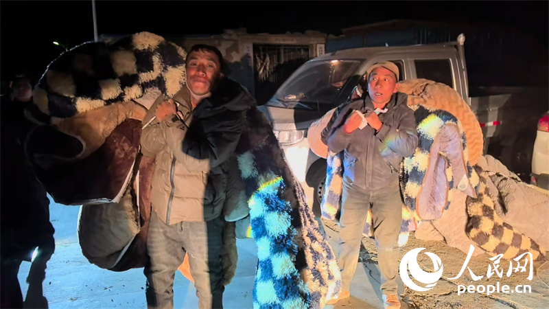 定日縣措果鄉(xiāng)吉定村村民在領(lǐng)取被褥等救災(zāi)物資。人民網(wǎng)記者 吳雨仁攝