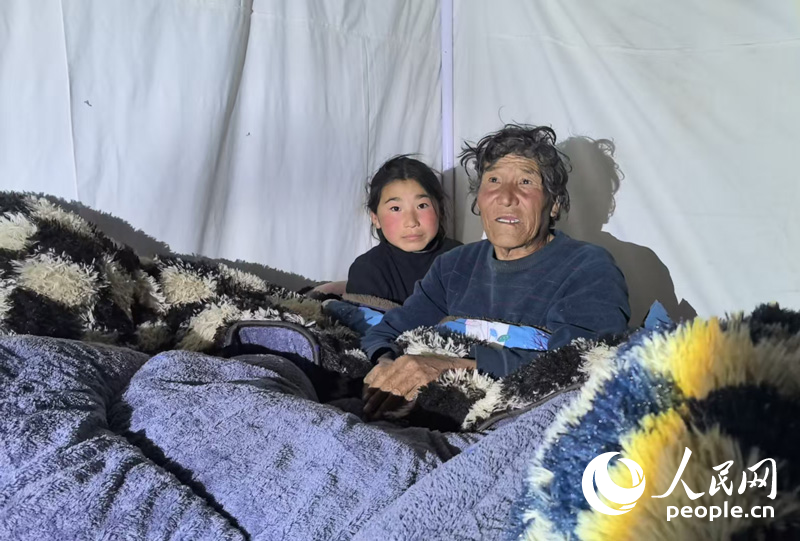 定日縣措果鄉(xiāng)吉定村村民扎西和他的孫女旦增桑旦在安置點(diǎn)帳篷內(nèi)。人民網(wǎng)記者 吳雨仁攝