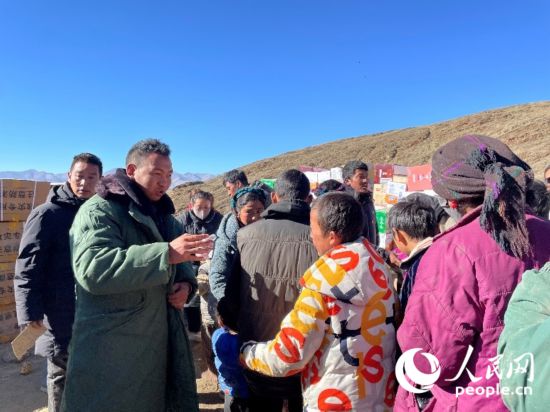 定日縣公安局干警頓珠次仁（左二）正在協(xié)助分發(fā)物資。人民網(wǎng)記者 郝潔攝