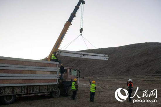 1月8日，在定日縣長所鄉(xiāng)古榮村安置點，工人們正在抓緊搭建移動板房。人民網(wǎng)記者 翁奇羽攝
