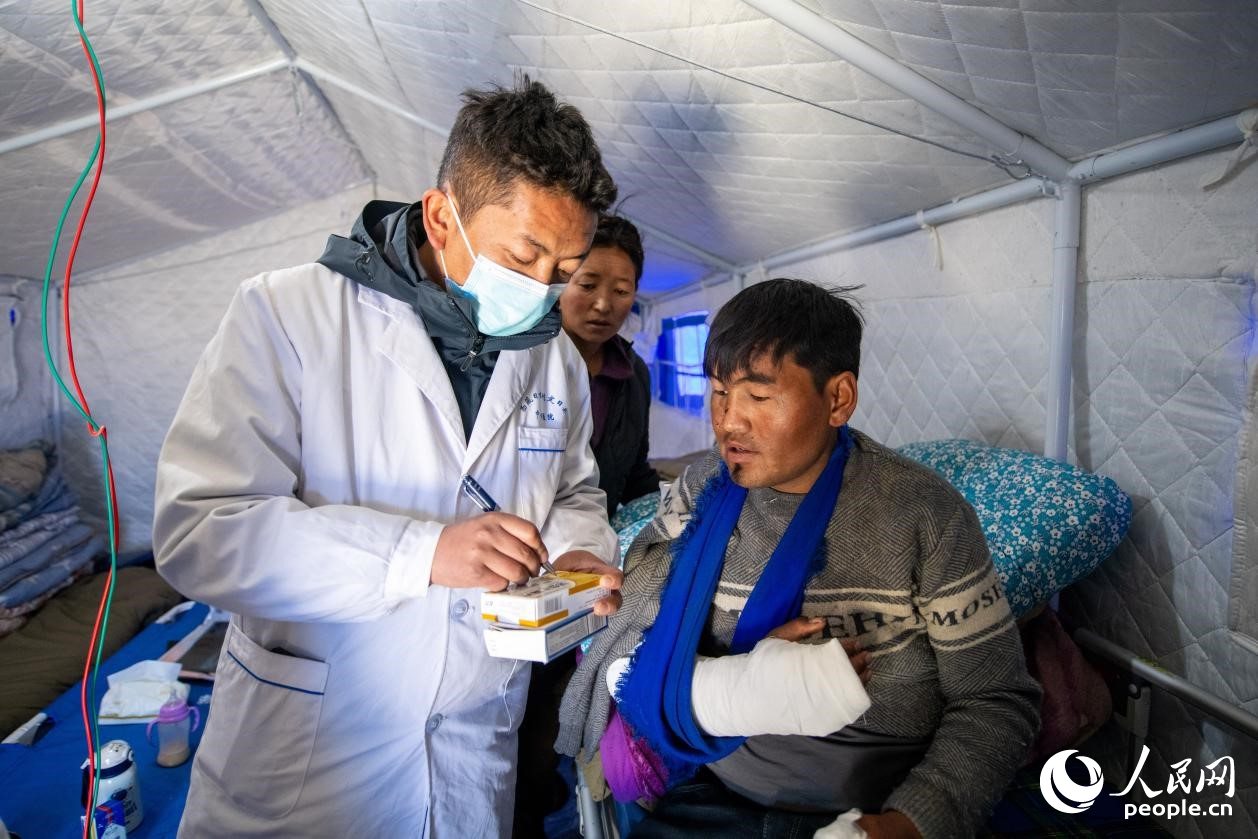 　醫(yī)生正在囑咐洛桑堅參如何用藥。人民網(wǎng)記者 翁奇羽攝