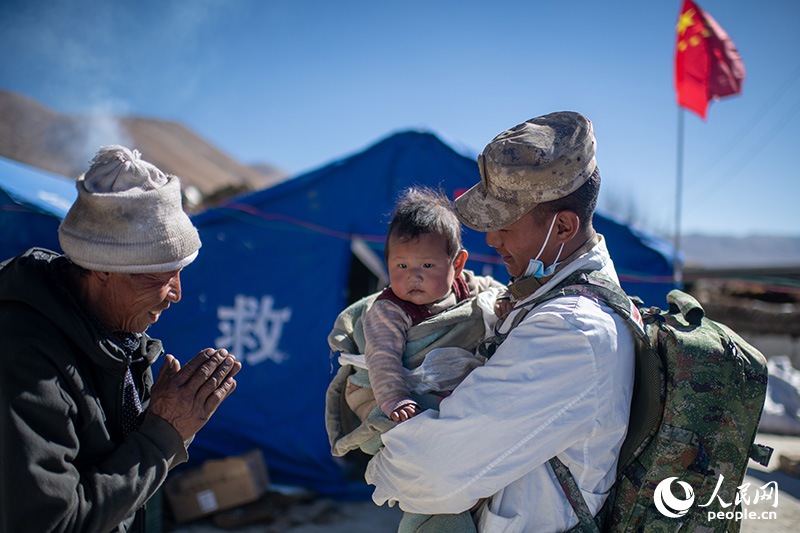 1月9日，在定日縣長所鄉(xiāng)古榮村安置點，受災(zāi)群眾感謝西藏軍區(qū)陸軍某部隊衛(wèi)生員的醫(yī)療救治。人民網(wǎng)記者 翁奇羽攝