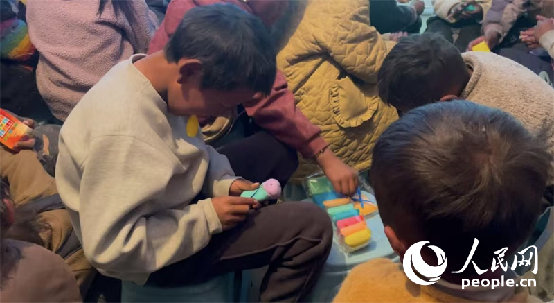 措果鄉(xiāng)塘仁村的孩子們正在用橡皮泥制作自己的情緒“小怪獸”。人民網(wǎng)記者 郝潔攝